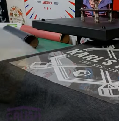 Heat transfer printing machine applying detailed custom logo onto tote bag fabric for personalized branding.
