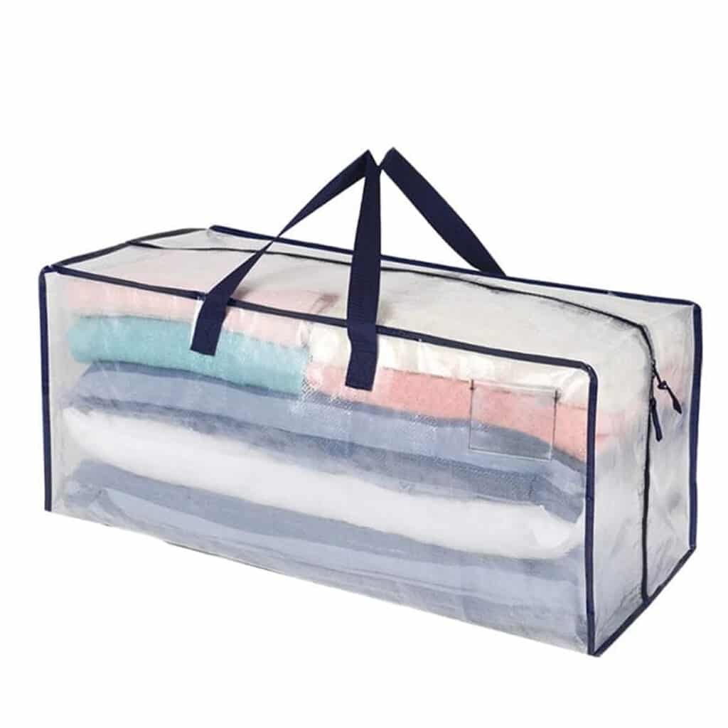 Clear storage bag with dark handles and trim, filled with folded clothes for easy organization and visibility