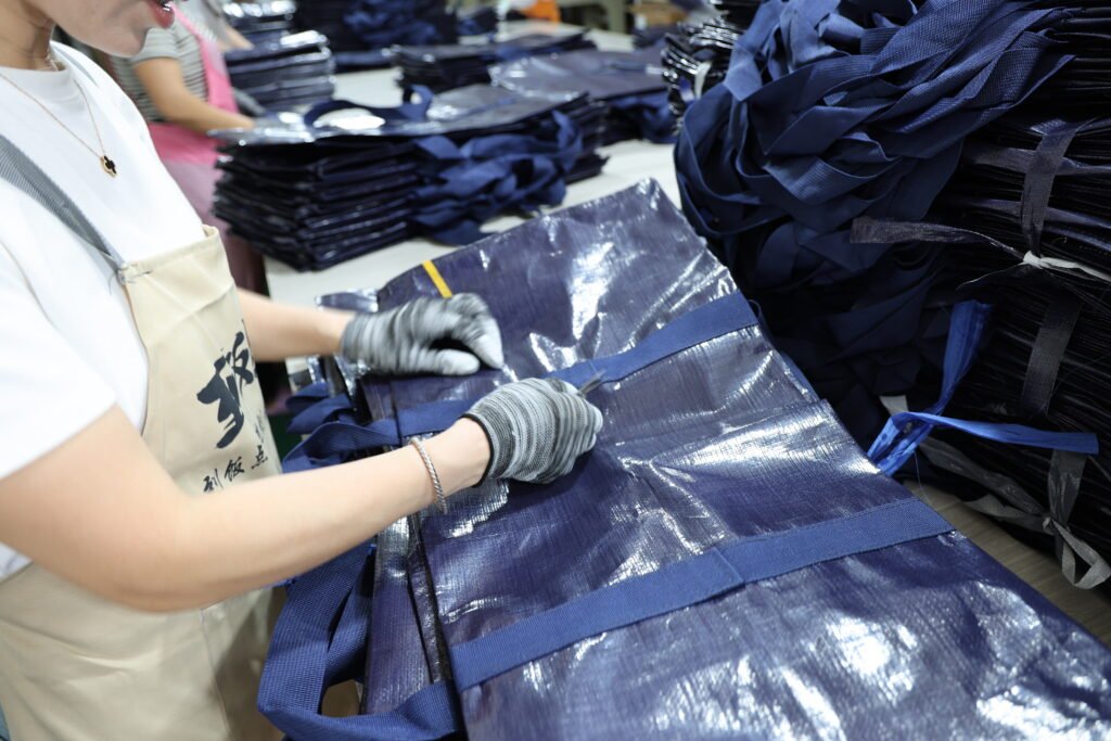 Close-up of staff checking zipper alignment on heavy-duty moving bags