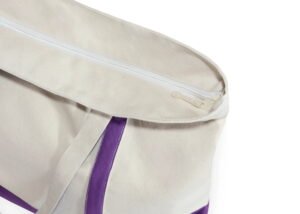 Beige canvas tote bag with purple straps and zipper closure for secure and eco-friendly shopping use