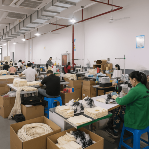 Factory workshop with workers sewing custom canvas tote bags for bulk production and wholesale orders