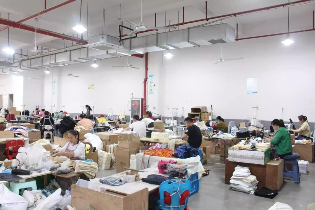 Professional sewing workshop with workers assembling custom canvas tote bags for bulk wholesale orders.
