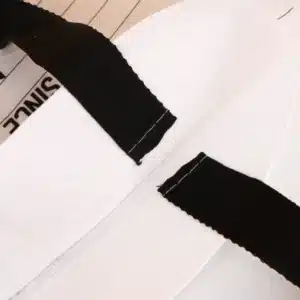Black woven handles stitched securely on a white polypropylene shopping bag