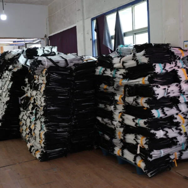 Des lots de sacs de courses réutilisables empilés sur des palettes à l'intérieur de la zone de production de l'usine.