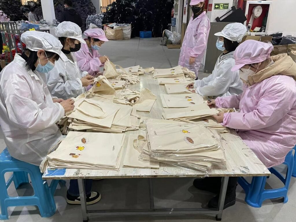 Team inspecting custom printed canvas tote bags for quality assurance before wholesale delivery