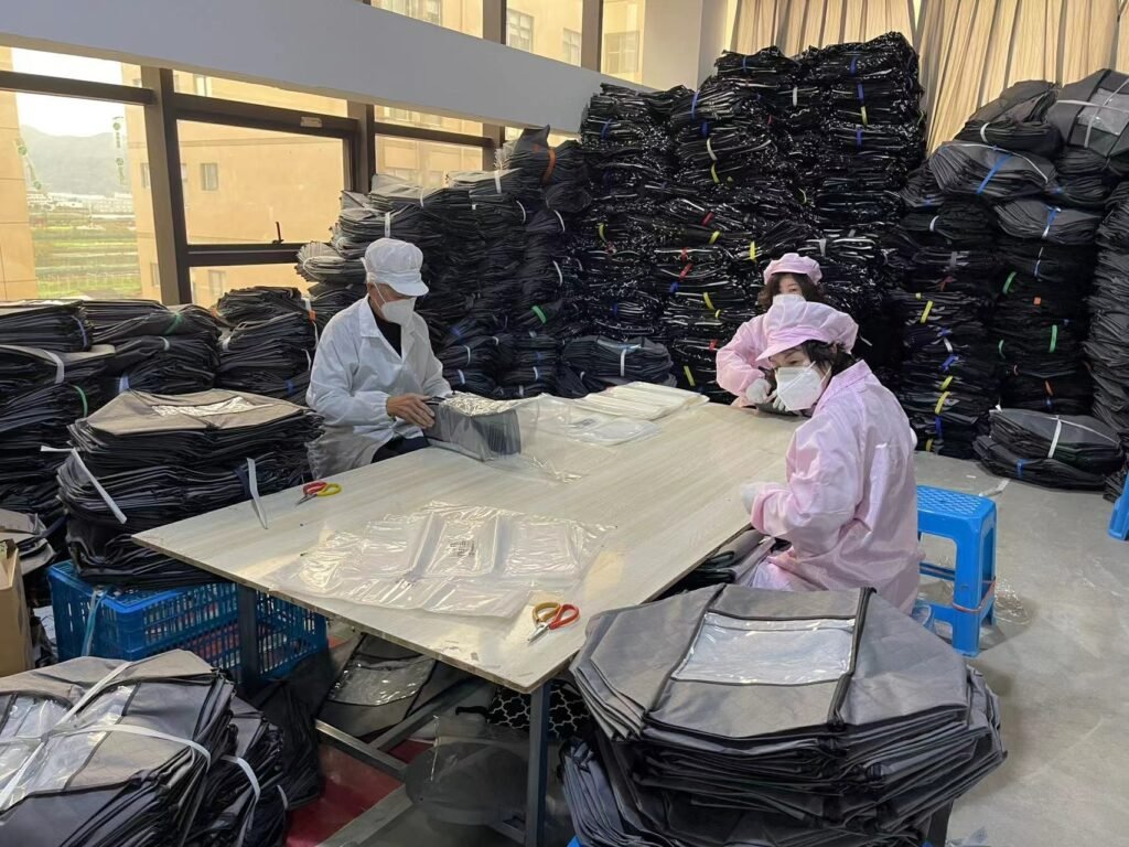 Workers packing black fabric storage bags in bulk order fulfillment area