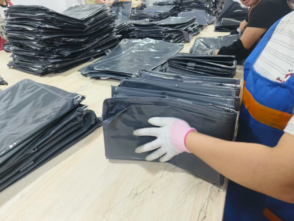 Worker folding moving bags before packaging for bulk shipment