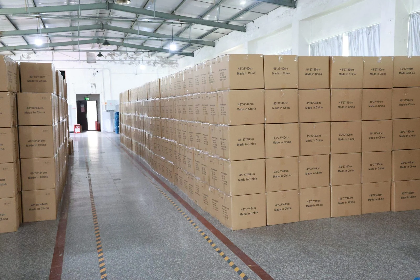 Shipping cartons stacked beside an aisle in the TIIOCTI warehouse