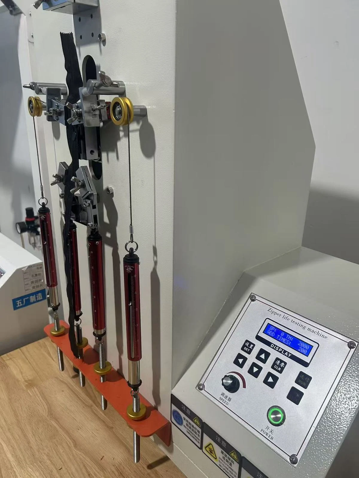 Moving Bags Manufacturing Tiiocti Side View Of The Zipper Test Fixture Hanging Weights And Digital Control Panel