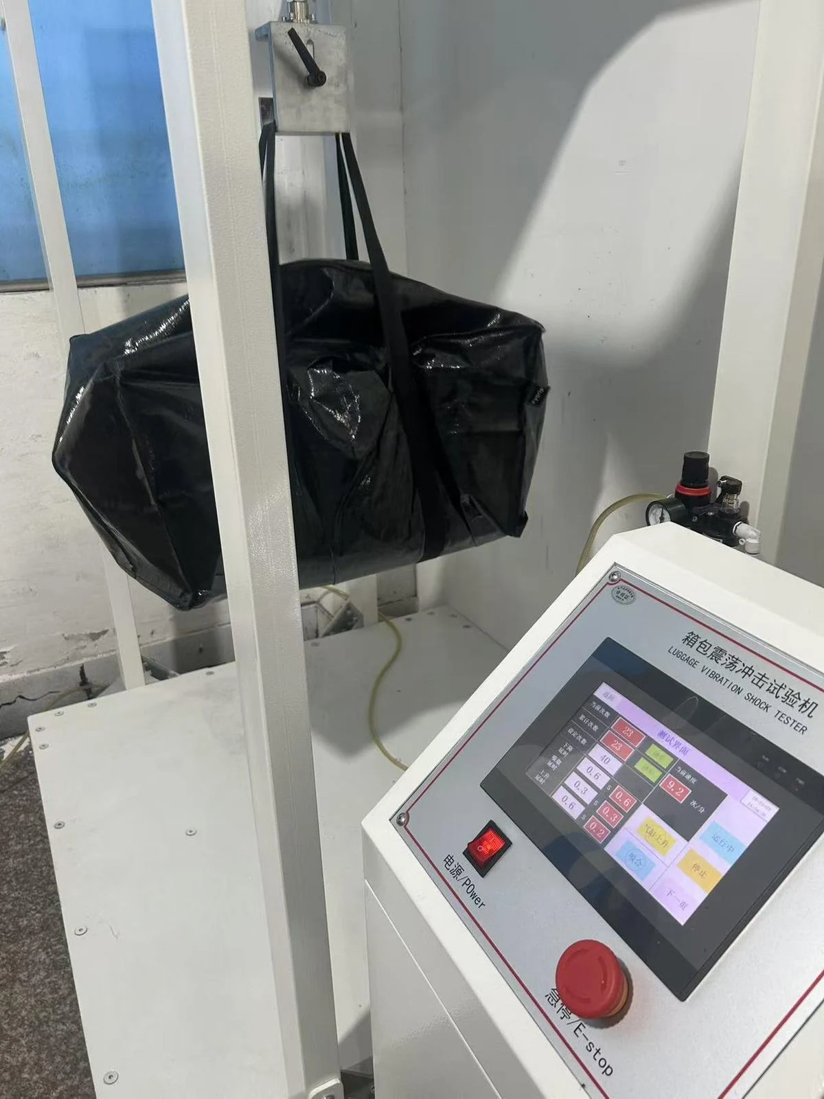 Moving Bags Manufacturing Tiiocti Front View Of A Filled Black Moving Bag Suspended From The Oscillation Test Rig With Controls In The Foreground
