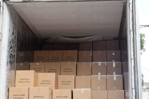 Open container filled with brown cartons of wholesale canvas tote bags ready for export shipping