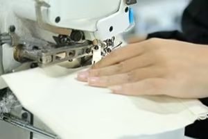 Close-up of sewing machine stitching fabric bag Close-up of sewing machine stitching heavy-duty canvas bag for durability