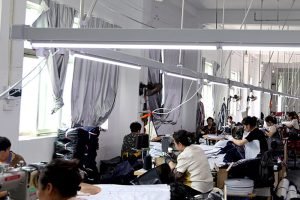 Bright sewing workshop where tailors are assembling high-quality custom canvas tote bags