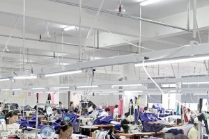 Busy sewing workshop with workers assembling textile products, ideal for mass production of tote bags, storage bags, and custom fabric items