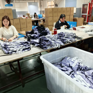 Workers assembling custom printed fabric bags in a manufacturing workshop