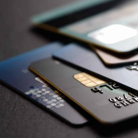 stack of multicolored credit cards on black background